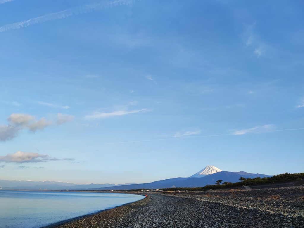 富士山。朝6時の静岡。遠方に富士山。波が引く音と小石と貝殻を踏む音が心を清めてくれる。