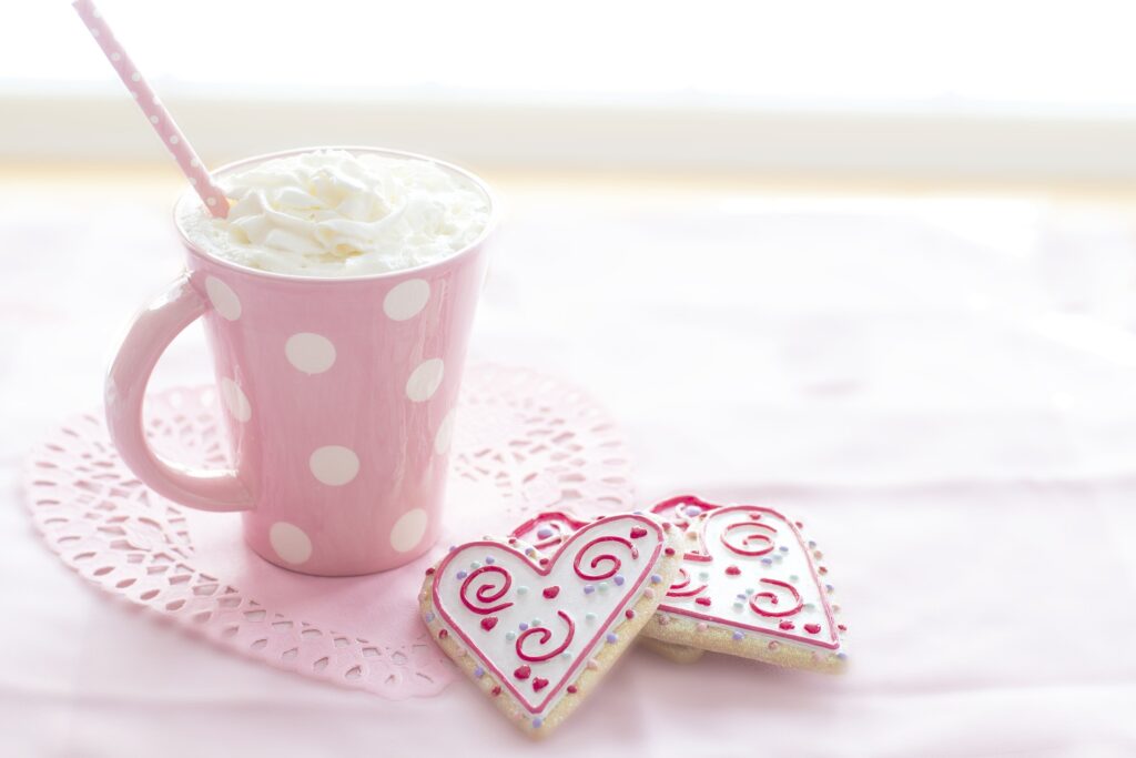 Crème de la crèmeのイメージ画像、ピンクのカップ、ピンクのストロー、英語表現、ハートのクッキー、ホイップクリーム